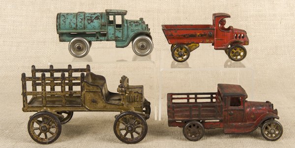 Four cast iron vehicles, to include a Kenton gaso: Four cast iron vehicles, to include a Kenton gasoline truck, an Arcade stake truck, etc., longest - 6 1/2''.