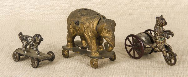 Cast iron elephant pull toy with a nodding head,: Cast iron elephant pull toy with a nodding head, 5'' l., together with a cast iron bear bell toy, 4'' l., and a cast iron dog pull toy, 3 3/4'' l.