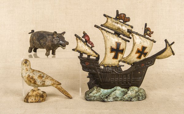 Cast iron ship doorstop, 11'' h., together with a: Cast iron ship doorstop, 11'' h., together with a cast iron bird finial and a mechanical cast iron pig.