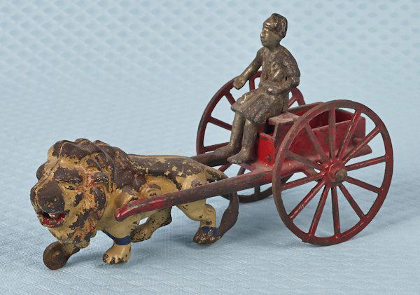 Kenton cast iron lion and cart pull toy, 7 1/2'' l: Kenton cast iron lion and cart pull toy, 7 1/2'' l.