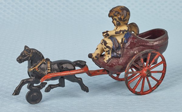 Kenton cast iron cherub in shoe pull toy, 8 1/2'': Kenton cast iron cherub in shoe pull toy, 8 1/2'' l.