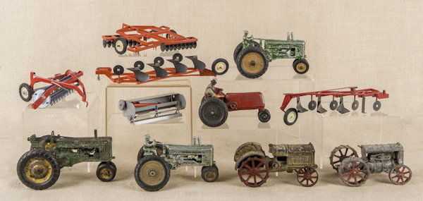 Cast iron McCormick Deering tractor, 7 1/4'' l.,: Cast iron McCormick Deering tractor, 7 1/4'' l., together with three white metal John Deer tractors, an Auburn Rubber tractor, and five Ertl and True Scale farm accessories, etc.