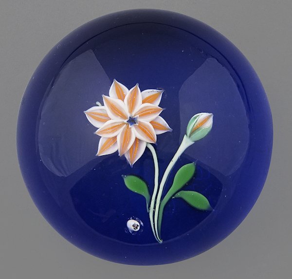 Baccarat paperweight with an orange and white flo: Baccarat paperweight with an orange and white flower on a translucent blue ground, dated 1974 and numbered 395, 2 3/4'' dia.