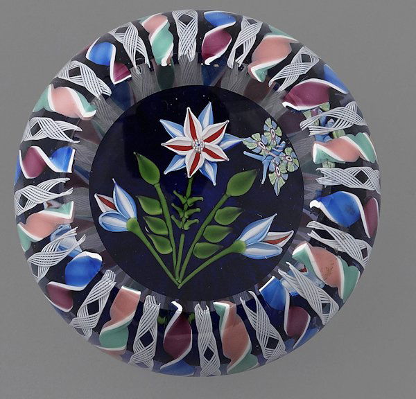 John Deacons ribbon crown overlay paperweight wit: John Deacons ribbon crown overlay paperweight with flowers and a butterfly in the center, signed in cane and dated 2003, 3'' dia.