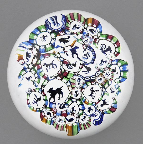 John Deacons scattered animal canes paperweight o: John Deacons scattered animal canes paperweight on a white ground, with a paper label on the underside, signed in cane and dated 2009, 2 3/4'' dia.