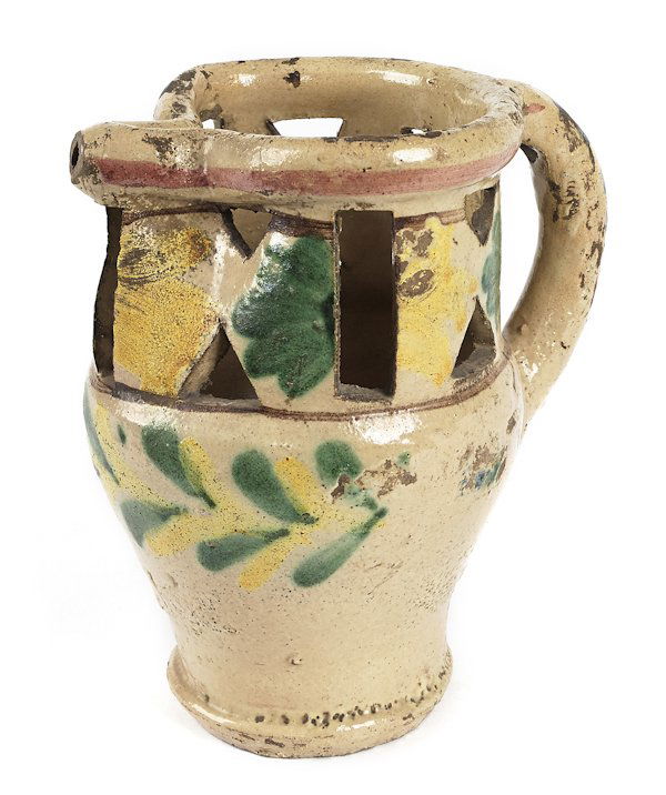 French redware puzzle mug, 19th c., with green, y: French redware puzzle mug, 19th c., with green, yellow, and blue slip glaze, 7'' h. Provenance: Clyde Youtz.