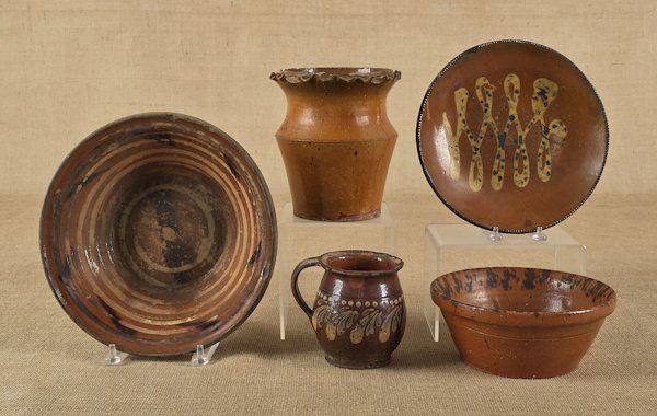 Five pieces of redware, 19th c., to include a sli: Five pieces of redware, 19th c., to include a slip decorated plate, a bowl with manganese decoration, etc., flower pot - 7 1/2'' h.
