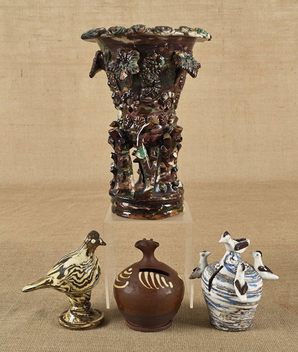 Four pieces of English redware, 19th c., to inclu: Four pieces of English redware, 19th c., to include a planter, 12'' h., a bird whistle, a bottle bank, and a bird bank.