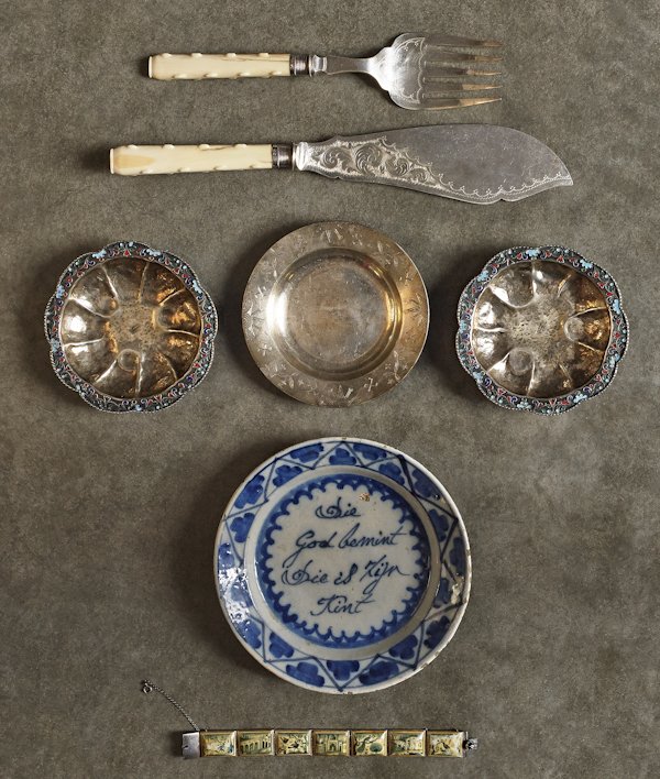Group of miscellaneous tablewares, to include a D: Group of miscellaneous tablewares, to include a Delft plate, two cloisonné silver trays, a Tiffany sterling silver tray, a fish set, and an Iranian bracelet.