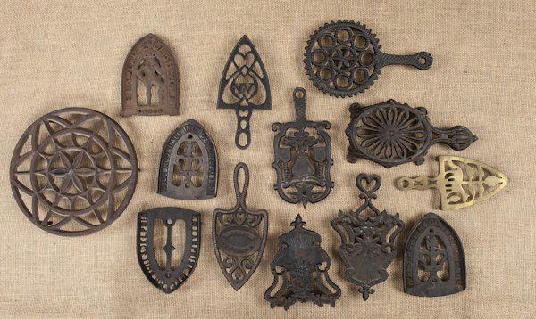Collection of twelve cast iron trivets, 19th/20th: Collection of twelve cast iron trivets, 19th/20th c., together with a brass example.