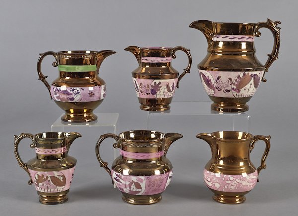 Six copper and pink lustre pitchers, tallest - 8'': Six copper and pink lustre pitchers, tallest - 8''.