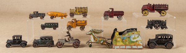 Twelve cast iron vehicles, early 20th c., longest: Twelve cast iron vehicles, early 20th c., longest - 5 1/2'', together with a Strauss tin wind-up Santa Claus, 11 1/2'' l.