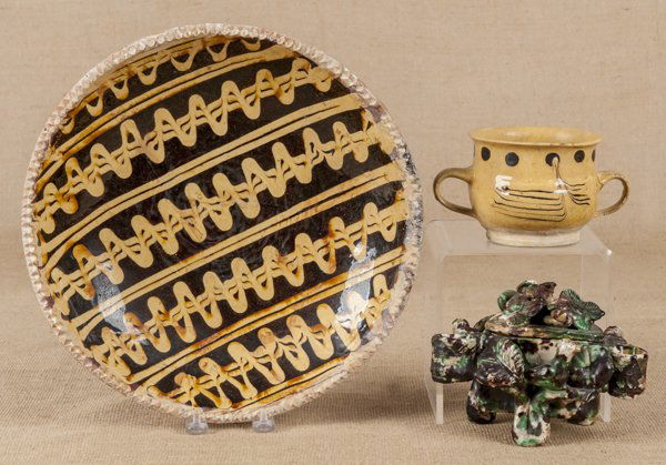 English slip decorated redware charger, 13 1/4'' d: English slip decorated redware charger, 13 1/4'' dia., together with a two-handled mug and a figural centerpiece.