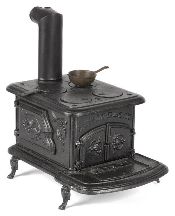 Cast iron Little Katie toy stove, 8'' h., 9 1/2'': Cast iron Little Katie toy stove, 8'' h., 9 1/2'' w., together with a miniature pan.