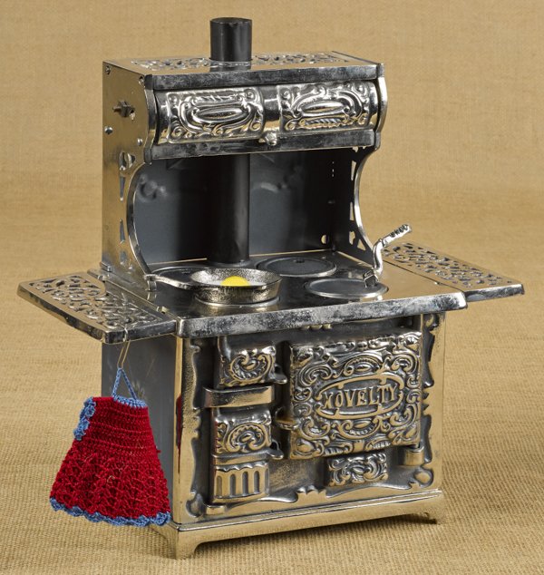Kenton cast iron, nickel, and tin Novelty toy s: Kenton cast iron, nickel, and tin Novelty toy stove, 12 1/2'' h., 12 3/4'' w., together with a miniature cast iron frying pan.