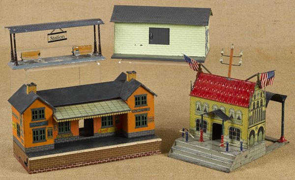 Three tin train stations, to include a German exa: Three tin train stations, to include a German example, 11'' h., 7'' w., an example with advertising, 8'' h., 13 1/4'' w., and a Fandor station, 4 1/4'' h., 10'' w., together with a Fandor warehouse, 5