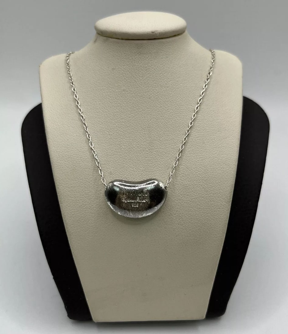 ?TIFFANY & CO. ELSA PERETTI BEAN NECKLACE STERLING SILVER 19" CHAIN: This elegant Tiffany & Co. necklace from the Elsa Peretti collection features a beautiful bean pendant made of high-quality sterling silver. The necklace has a length of 19 inches and is closed wi