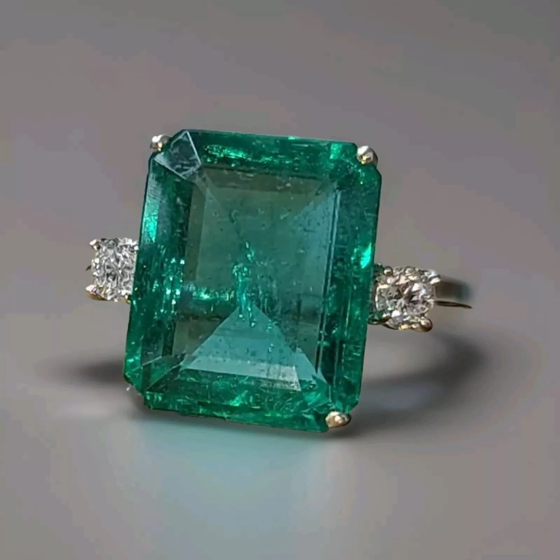 14K WHITE GOLD ENGAGEMENT RING 7.72CT.NATURAL GREEN EMERALD EMERALD CUT GIA CERT: This stunning 14K white gold engagement ring boasts a beautiful 7.72 carat natural green emerald in an emerald cut, with a secondary diamond accent. The cocktail style ring is perfect for an engagemen