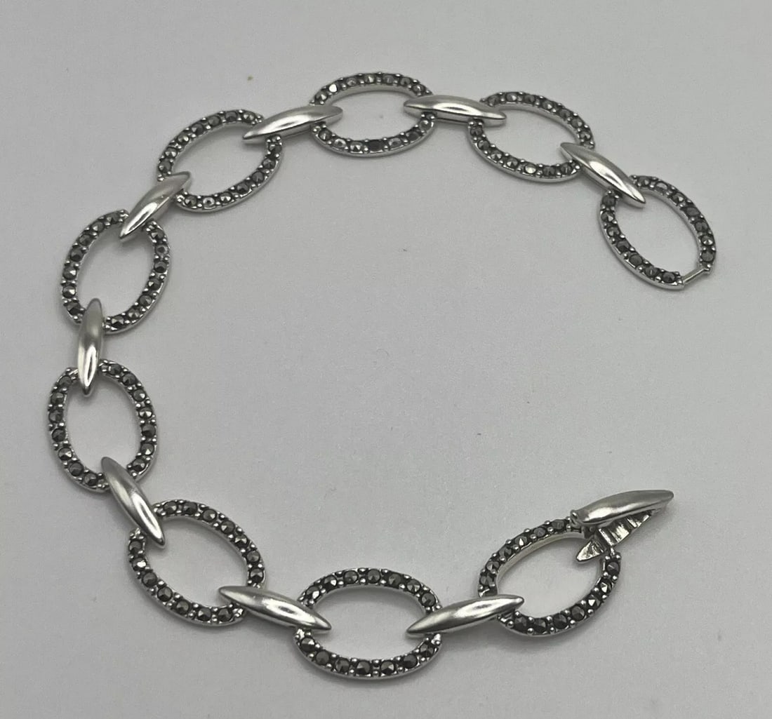STERLING SILVER & MARCASITE 7.5" OVAL LINK BRACELET: Add a touch of elegance to your wrist with this stunning Sterling Silver & Marcasite 7.5" Oval Link Bracelet. The bracelet features a beautiful oval-shaped link chain with marcasite accents that give
