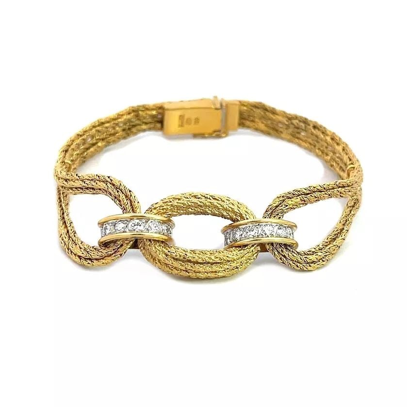 BUCHERER DIAMOND BRACELET 18K YELLOW GOLD LOOP STYLE SWISS: This elegant bracelet is by designer Bucherer, it is crafted from 18k yellow gold featuring a multi-chain twisted rope like style. The center piece is an oval ring with two half dome curved clamp with