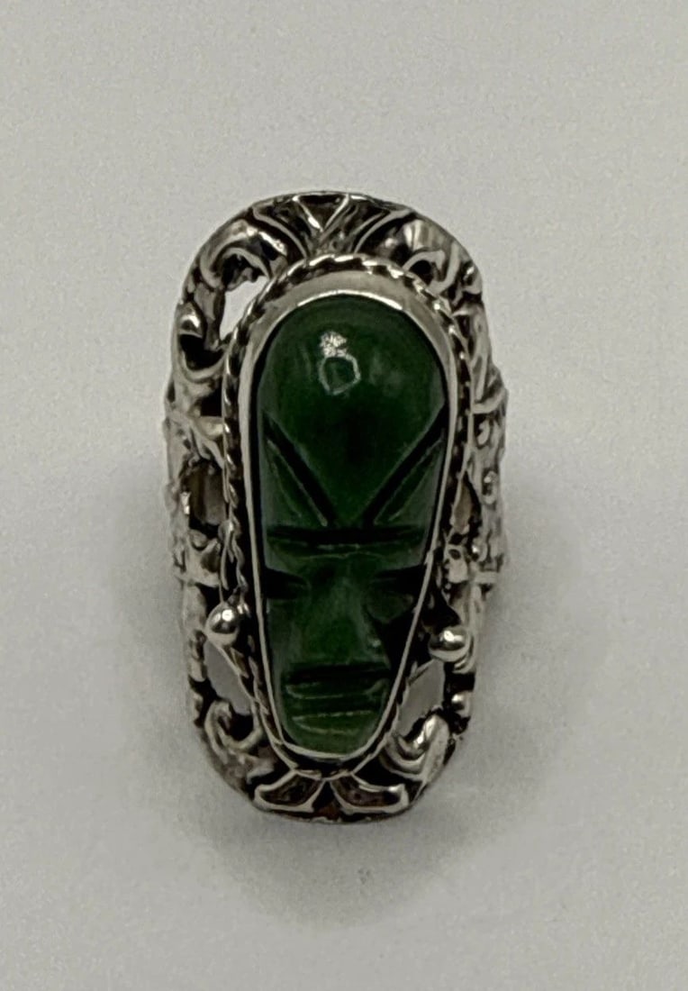 GREEN AGATE TRIABAL MASK POISION RING - ADJUSTABLE SIZING: GREEN AGATE TRIABAL MASK POISION RING - ADJUSTABLE SIZING Crafted with precision, this Green Agate Tribal Mask Poison Ring showcases a unique design that's both striking and timeless. The centerpiece