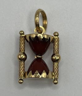 14K YELLOW GOLD HOUR GLASS CHARM: 14K YELLOW GOLD HOUR GLASS CHARM This 14K yellow gold charm is a timeless piece that is sure to add a touch of elegance to any bracelet or necklace. The charm is designed in the shape of an hourglass