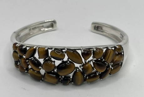 TIGER'S EYE CUFF BRACELET: TIGER'S EYE CUFF BRACELET This stunning cuff bracelet features a beautiful Tiger's Eye stone set in a 925 silver frame. The warm brown tones of the stone perfectly complement the silver metal, creatin