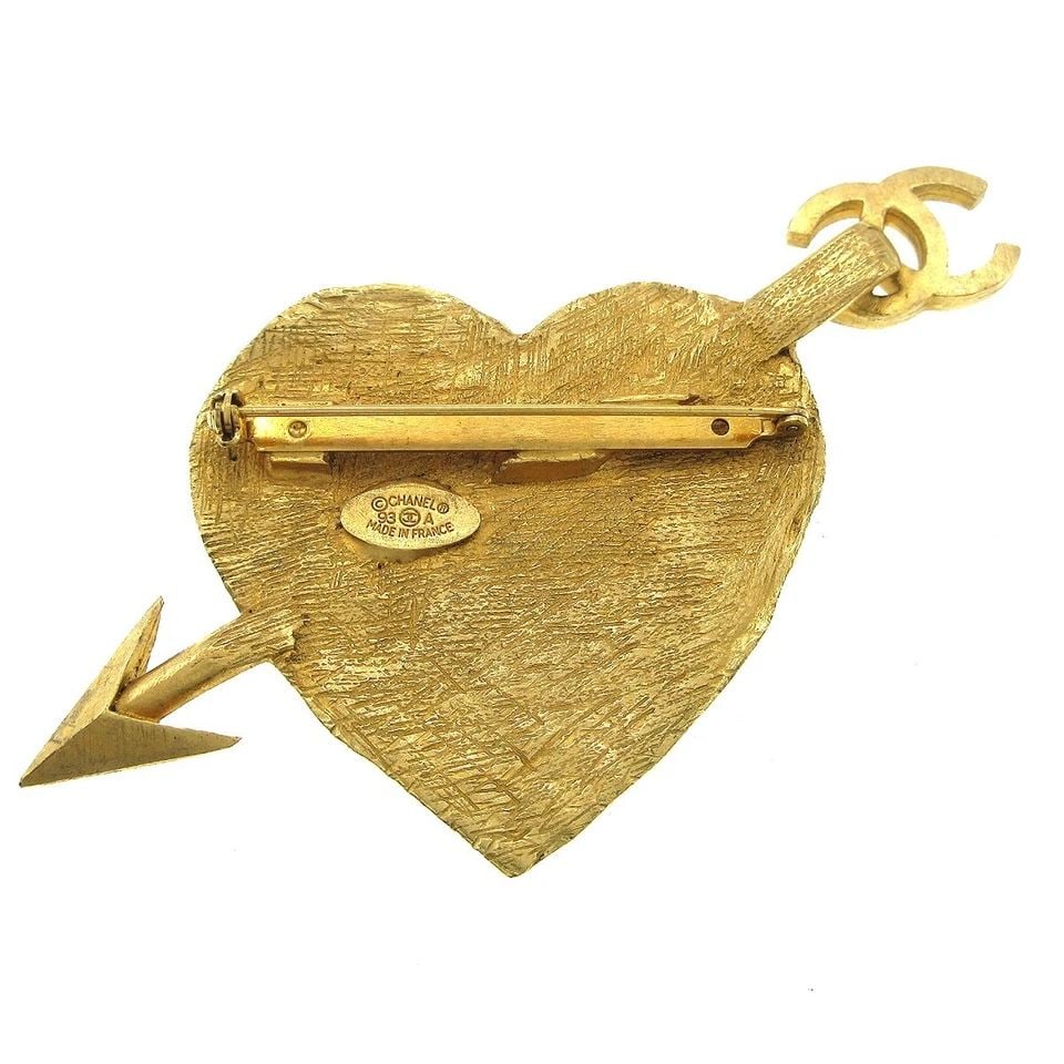 CHANEL BOW AND ARROW HEART BROOCH PIN GOLD: CHANEL BOW AND ARROW HEART BROOCH PIN GOLD Number 93A Size(Inch) W 3.9 " x H 2.0 " Size(CM) W 10.0 x H 5.0 cm Color : Gold Material : Gold-plated Comes with : - Country of Manufacture : France