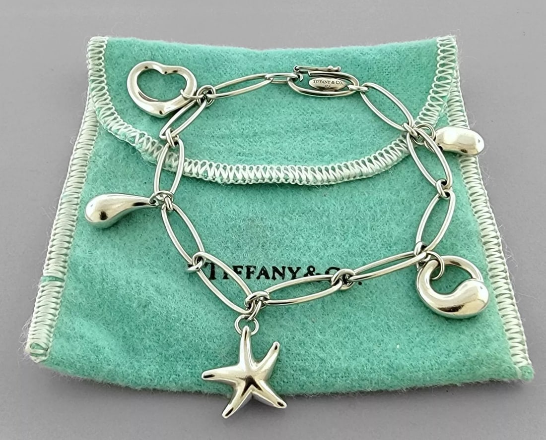 TIFFANY & CO. STERLING SILVER 5 CHARM ELSA PERETTI STAR HEART BRACELET: TIFFANY & CO. STERLING SILVER BRACELET Tiffany & Co. Sterling silver charm Bracelet Elsa peretti 5 charm bracelet Measures 7.25" Long Tiffany pouch included Pre-owned, in good condition, please refer