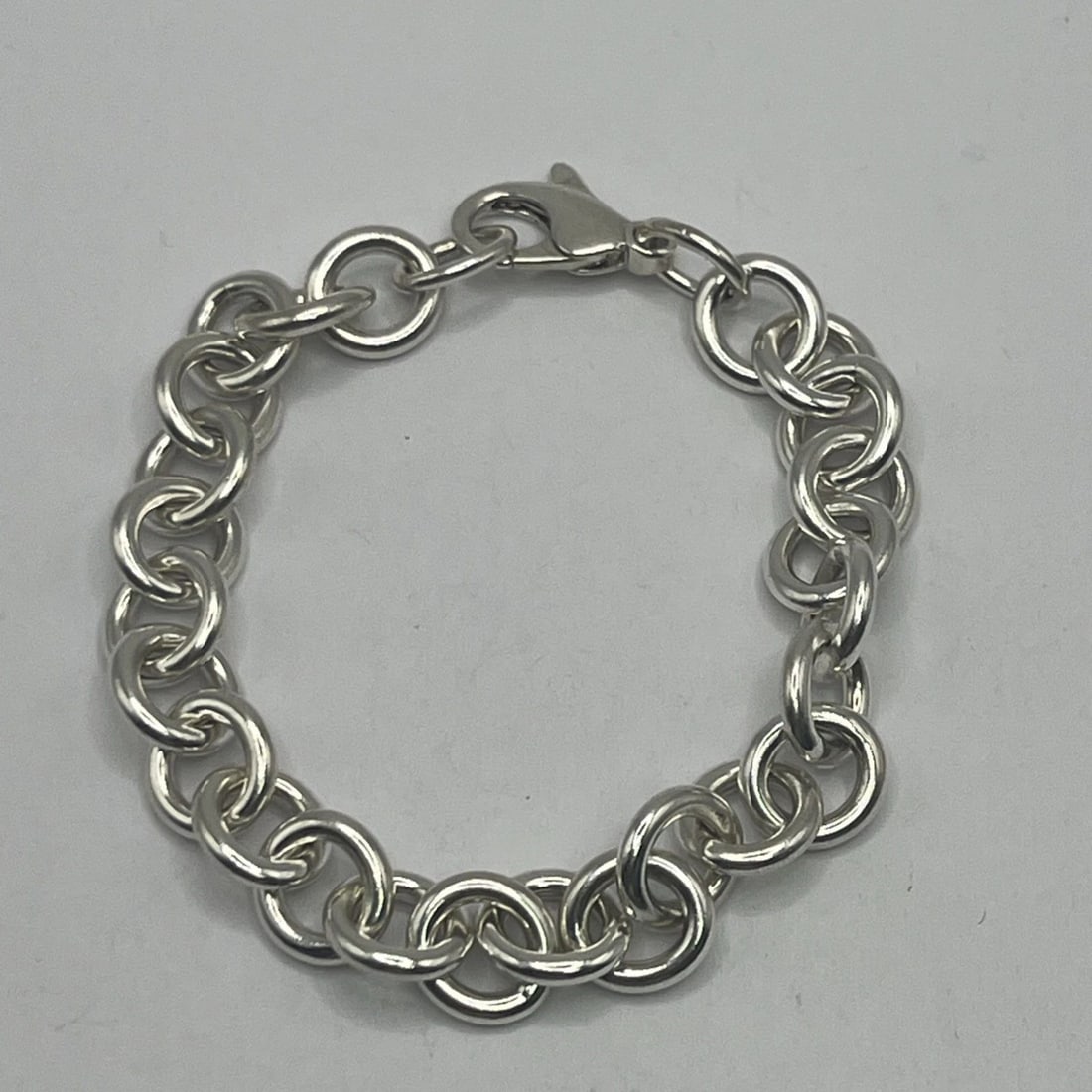 7.5" CIRCLE LINK CHARM BRACELET 28.8 GRAMS: 7.5" CIRCLE LINK CHARM BRACELET 28.8 GRAMS 7.5" CIRCLE LINK CHARM BRACELET 28.8 GRAMS This is a 7.5-inch charm bracelet made of sterling silver with a metal purity of 925. The bracelet features circle