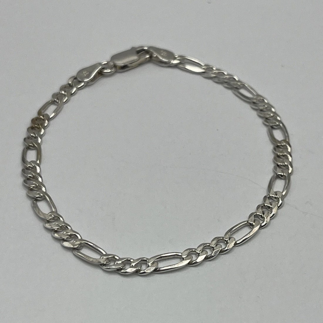 STERLING SILVER FIGARO BRACELET 7": STERLING SILVER FIGARO BRACELET 7" STERLING SILVER FIGARO BRACELET 7" The product is a 7 inch Sterling Silver Figaro Bracelet made with 925 metal purity. This chain-style bracelet does not feature a m