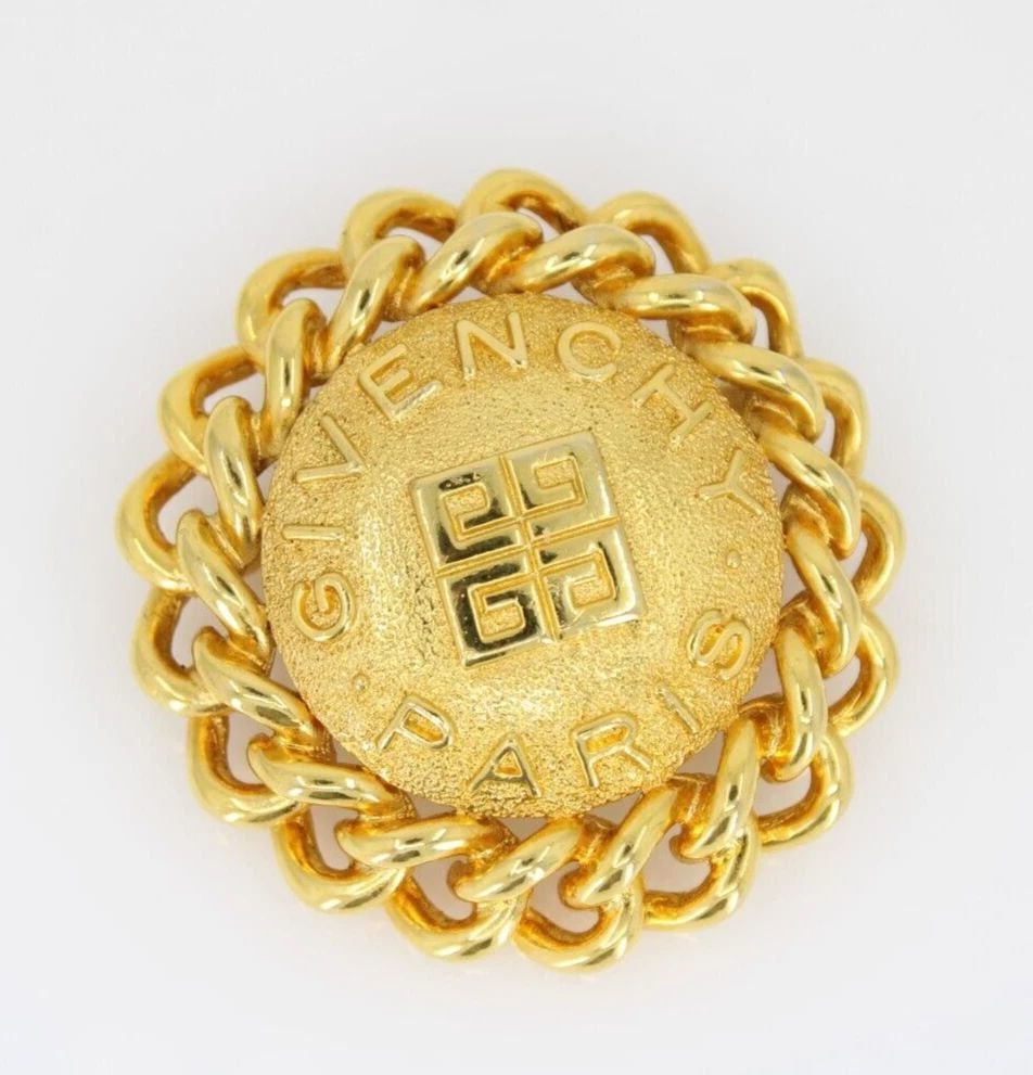 VINTAGE 1980'S GIVENCHY GOLD PLATED 2" ROUND LOGO STATEMENT PIN BROOCH SIGNED: VINTAGE 1980'S GIVENCHY GOLD PLATED 2" ROUND LOGO STATEMENT PIN BROOCH SIGNED VINTAGE 1980'S GIVENCHY GOLD PLATED 2" ROUND LOGO STATEMENT PIN BROOCH SIGNED Description Vintage 1980's Givenchy Gold Ton