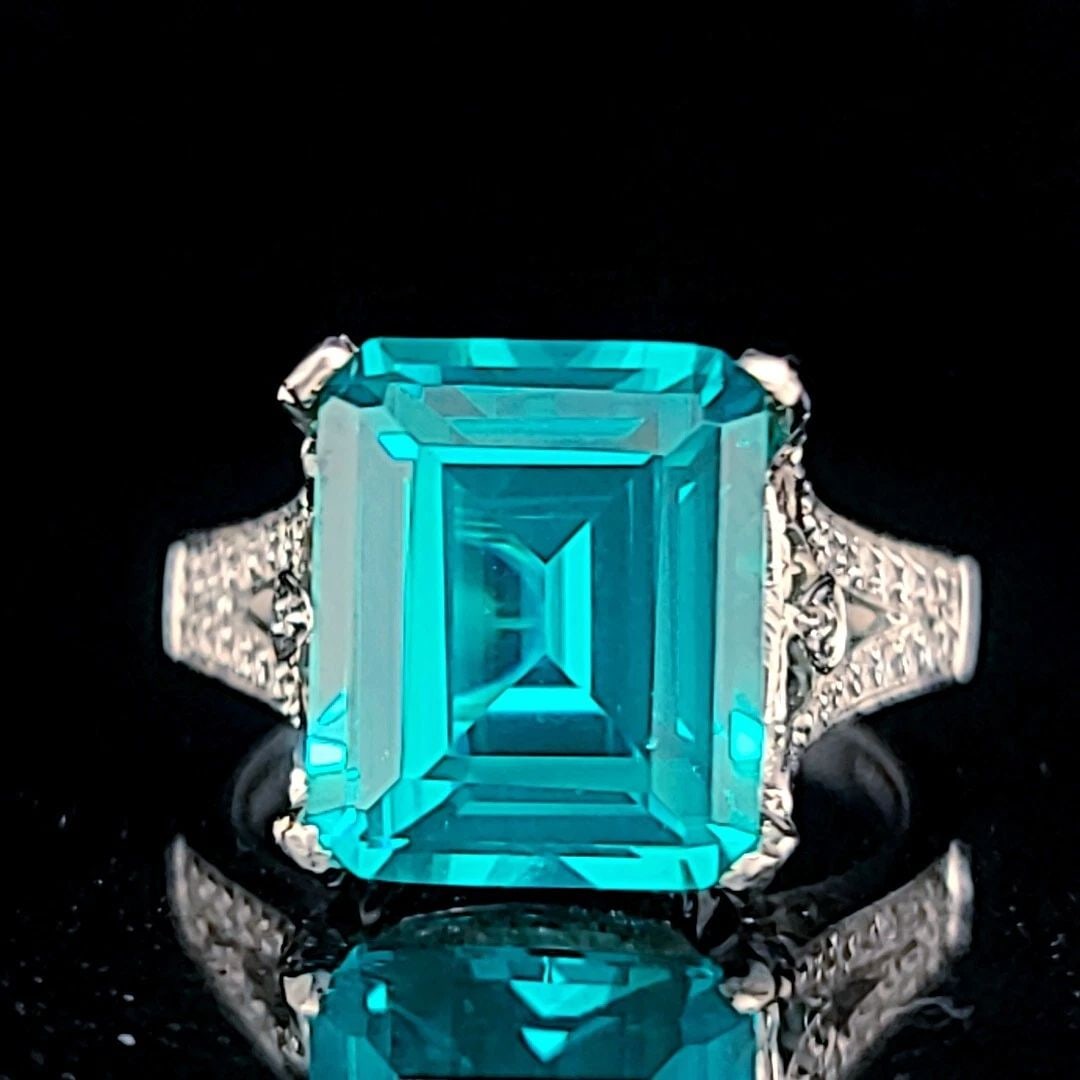 18K WHITE GOLD ENGAGEMENT RING 9.07CT.CARIBBEAN BLUE TOURMALINE EMERALD SHAPE: 18K WHITE GOLD ENGAGEMENT RING 9.07CT.CARIBBEAN BLUE TOURMALINE EMERALD SHAPE GORGEOUS 18k white gold engagement ring gem Caribbean blue tourmaline emerald shape The center lab-grown blue tourmaline e