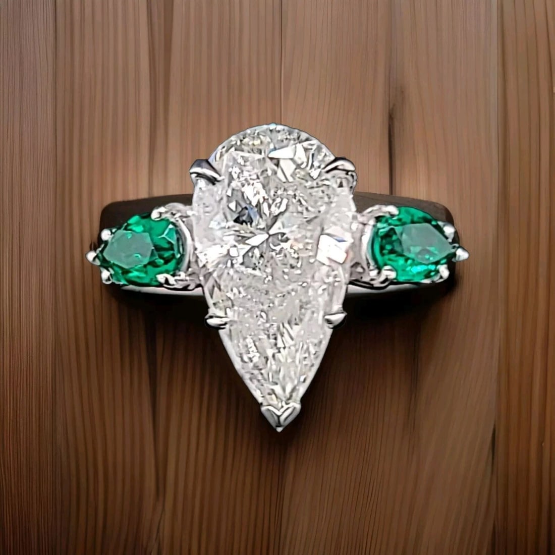 PLATINUM VINTAGE ENGAGEMENT RING 4.02CT. NATURAL PEAR SHAPE DIAMOND CIRC 1950'S: PLATINUM VINTAGE ENGAGEMENT RING 4.02CT. NATURAL PEAR SHAPE DIAMOND I1-I This stunning vintage platinum ring features a beautiful 4.02ct natural pear-shaped diamond, surrounded by two sparkling green