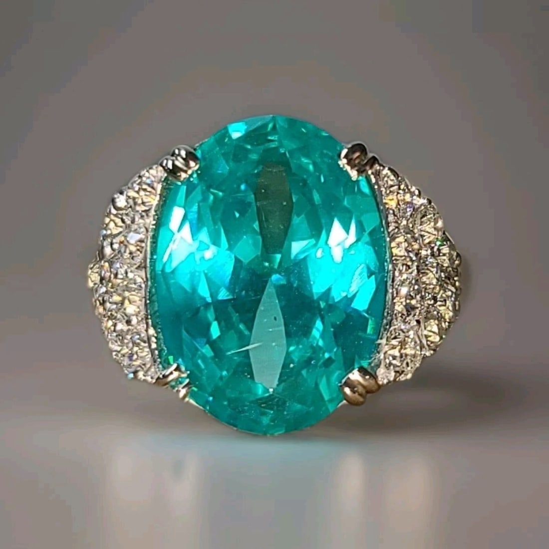 14K WHITE YELLOW GOLD COCKTAIL RING 16.53CT. LAB GROWN PARAIBA TOURMALINE OVAL: 14K WHITE YELLOW GOLD COCKTAIL RING 16.53CT. LAB GROWN PARAIBA TOURMALINE OVAL This 14K white gold cocktail ring features a stunning 16.53CT lab-grown Paraiba Tourmaline with an oval cut, accented wit