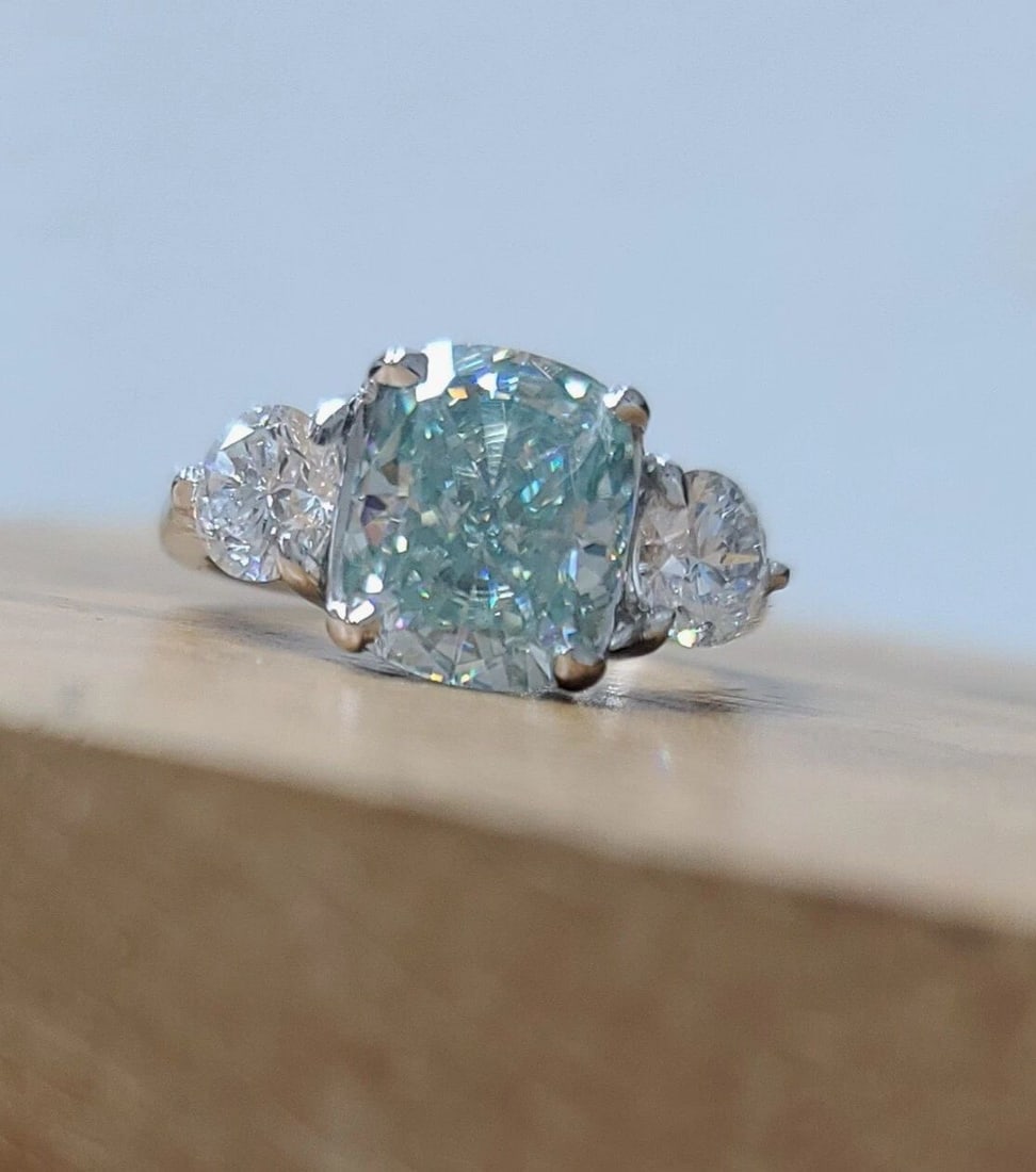 VINTAGE PLATINUM 3.49CT. BLUE MOISSANITE DIAMOND ENGAGEMENT RING CUSHION CUT: VINTAGE PLATINUM 3.49CT. BLUE MOISSANITE DIAMOND ENGAGEMENT RING CUSHION CUT Vintage platinum engagement three-stone ring. Center set gorgeous blue moissanite diamond weight 3.49CT. In cushion cut siz