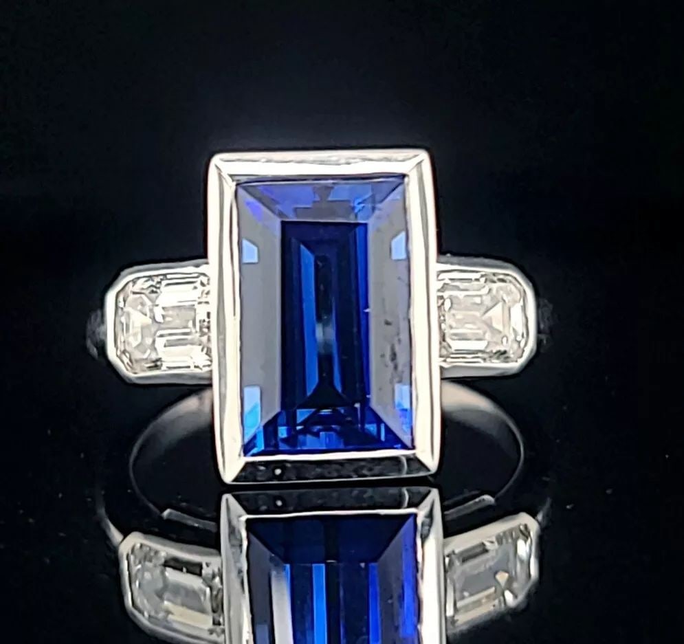 14K WHITE GOLD ITALIAN DESIGN 4.65CT. GEM BLUE SAPPHIRE EMERALD SHAPE: 14K WHITE GOLD ITALIAN DESIGN 4.65CT. GEM BLUE SAPPHIRE EMERALD SHAPE Gorgeous 14k white gold blue sapphire in an emerald shape bezel setting. Center lab-grown sapphire weight 4.65ct. size 11x7mm very