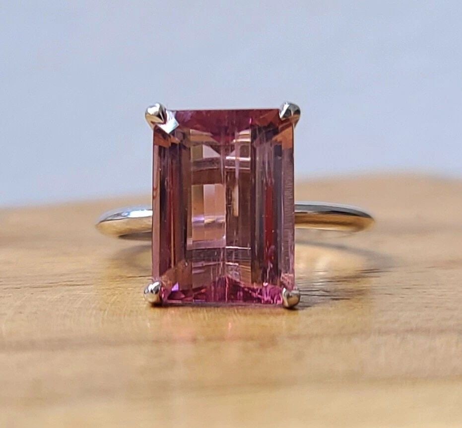 VINTAGE 14K WHITE GOLD ENGAGEMENT RING 5.27CT. NATURAL PINK TOURMALINE: VINTAGE 14K WHITE GOLD ENGAGEMENT RING 5.27CT. NATURAL PINK TOURMALINE This stunning 14k white gold ring features a breathtaking 5.27ct natural pink tourmaline in an emerald cut. The ring is perfect f
