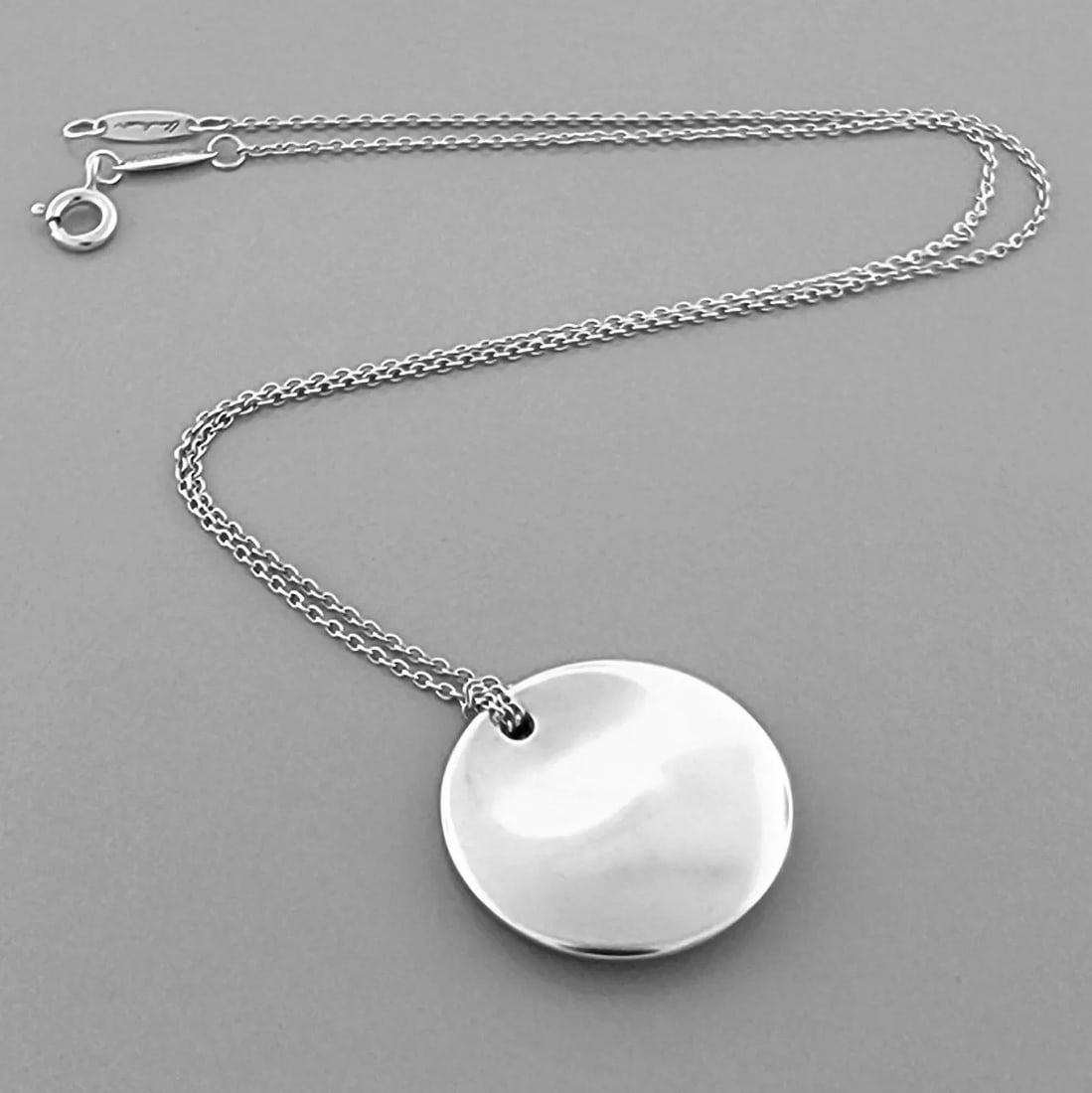 TIFFANY & CO. STERLING SILVER CIRCLE DISC ELSA PERETTI CORD NECKLACE: TIFFANY & CO. STERLING SILVER DISC NECKLACE Tiffany & Co. Sterling silver Elsa Peretti Disc Necklace Measures 16" Long Disc measures 0.91" Wide Pre-owned, in good condition, minor wear, please refer t