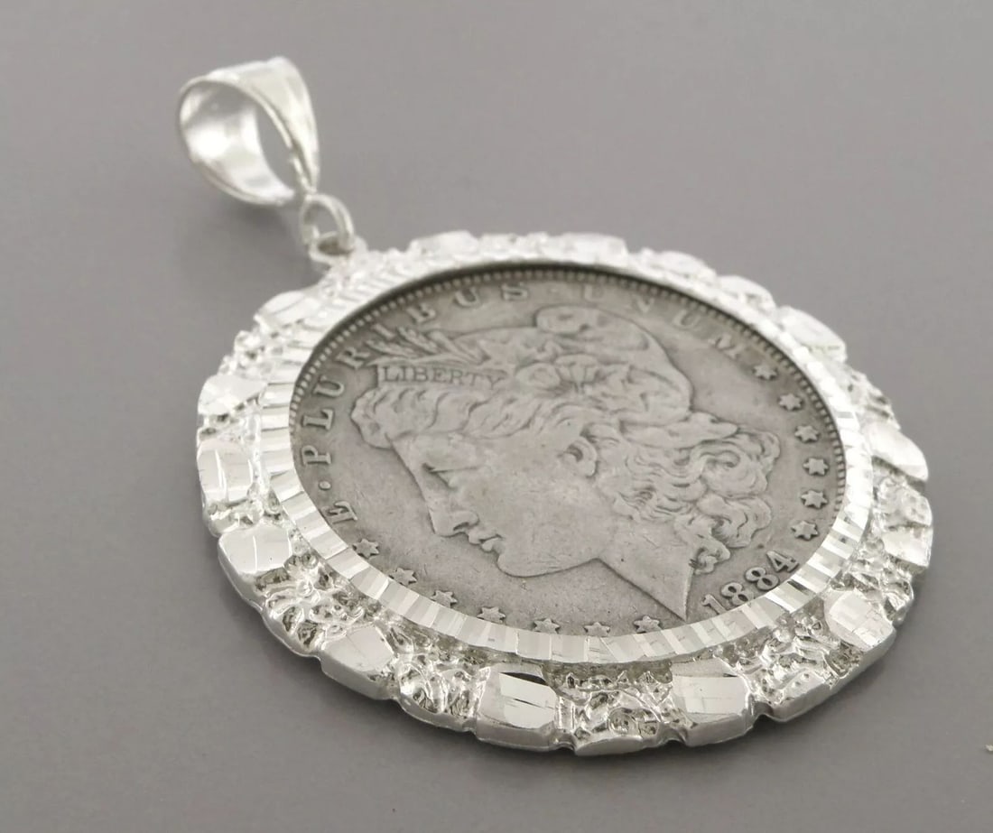 VINTAGE 1884 MORGAN DOLLAR COIN SILVER NUGGET PENDANT: VINTAGE STERLING SILVER COIN Vintage 1884 silver morgan dollar set in a nugget bezel pendant Measures 1.86" wide Coin is in good condition for it's age Vintage, Pre-owned, in good condition, please re