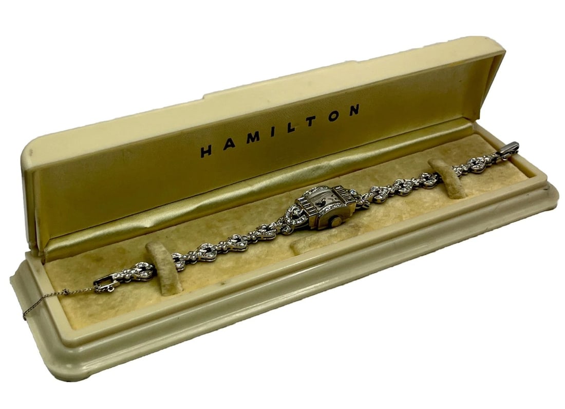 HAMILTON PLATINUM AND DIAMOND COCKTAIL WATCH: HAMILTON PLATINUM AND DIAMOND COCKTAIL WATCH This exquisite Hamilton Lady Hamilton wristwatch is a perfect blend of luxury and elegance. The platinum case and bracelet, along with the diamond bezel, e