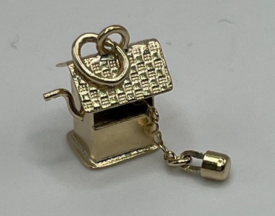 14KT YELLOW GOLD WISHING WELL CHARM WITH BUCKET: 14KT YELLOW GOLD WISHING WELL CHARM WITH BUCKET This 14KT yellow gold charm features a charming wishing well design with a bucket. Crafted with high-quality materials, it is perfect for adding to your