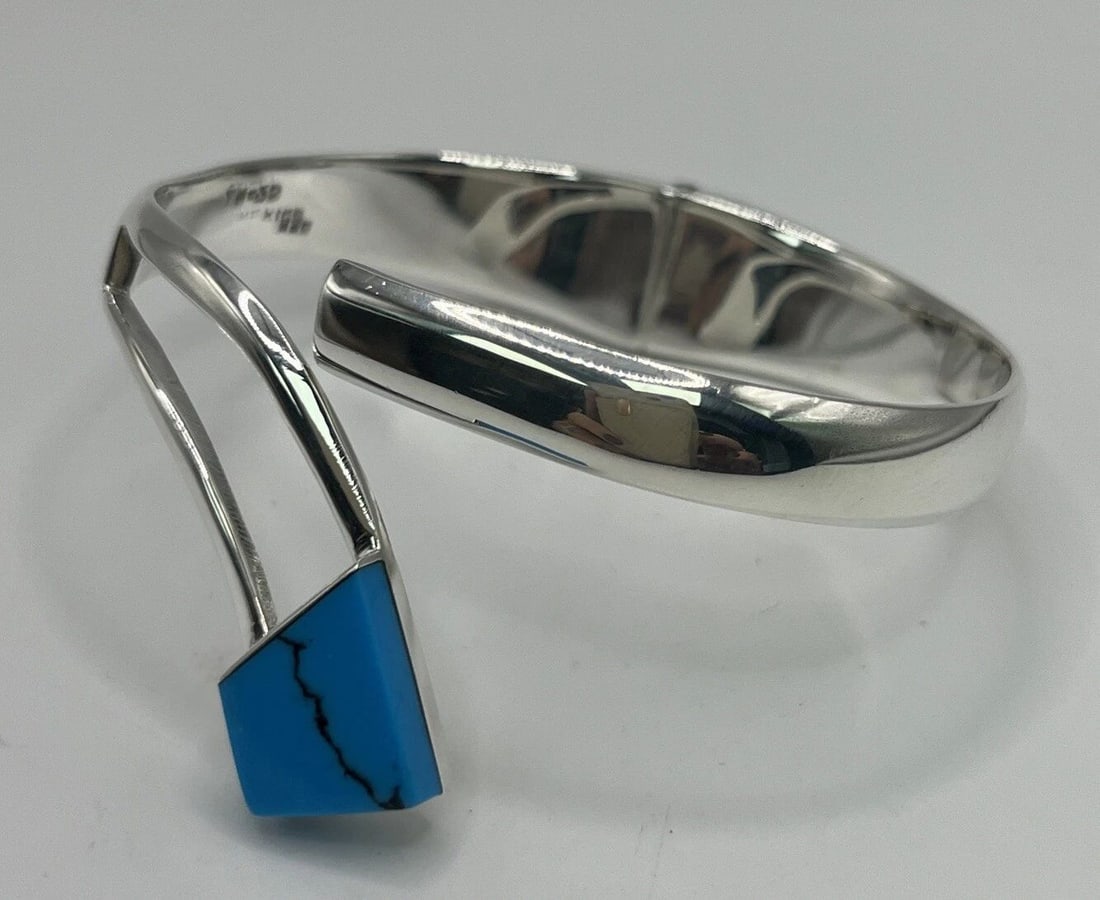 STERLING SILVER & TURQUOISE HINGE BRACELET: STERLING SILVER & TURQUOISE HINGE BRACELET This beautiful bracelet is crafted from sterling silver and features a stunning turquoise stone. The blue color of the stone is complemented by the Southwest