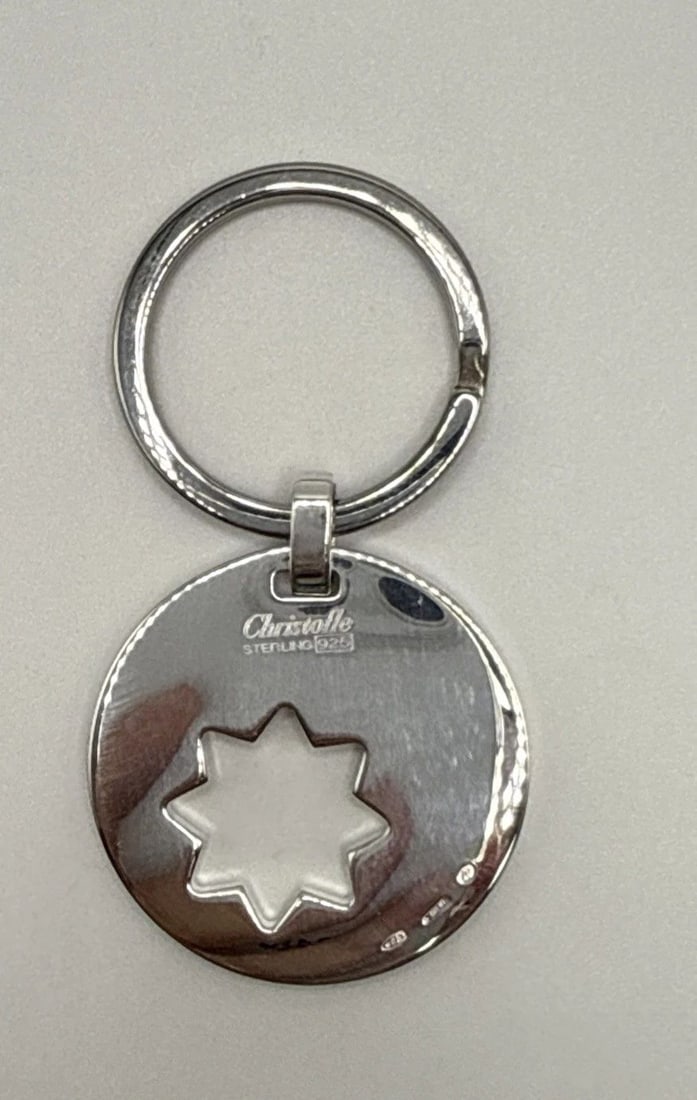 CHRISTOFLE STERLING SILVER STAR KEYCHAIN: CHRISTOFLE STERLING SILVER STAR KEYCHAIN The Christofle Sterling Silver Star Keychain is a modern collectible made of high-quality silver. Its sleek design and star shape make it a stylish accessory f