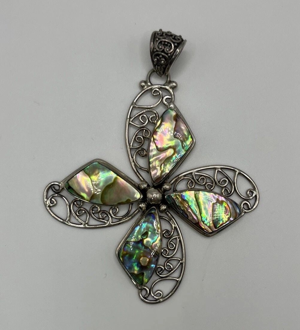 INDONESIAN DESIGNER MERAV STERLING SILVER MOTHER OF PEARL SHELL BEADED CROSS: INDONESIAN DESIGNER MERAV STERLING SILVER MOTHER OF PEARL SHELL BEADED CROSS Add a unique and elegant touch to your jewelry collection with this Indonesian designer Merav pendant. The pendant features