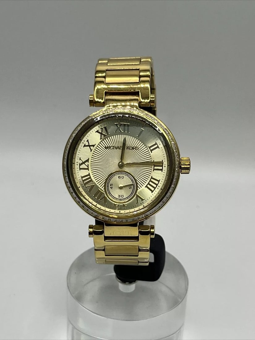 MICHAEL KORS WATCH (NEW): MICHAEL KORS WATCH (NEW) This elegant Michael Kors wristwatch is a must-have for any fashion-forward individual. With a stainless steel and metal band and a round watch face, this watch is perfect for