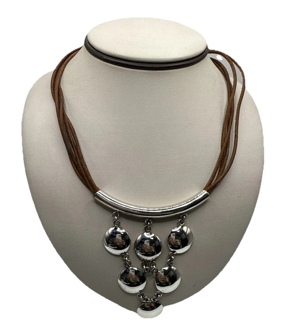 BROWN SUEDE MULTI STRAND MODESTIST CHOKER NECKLACE WTH SILVER DETAILS: BROWN SUEDE MULTI STRAND MODESTIST CHOKER NECKLACE WTH SILVER DETAILS This Brown Suede Multi Strand Modestist Choker Necklace with Silver Details is a stylish and elegant accessory that showcases a un