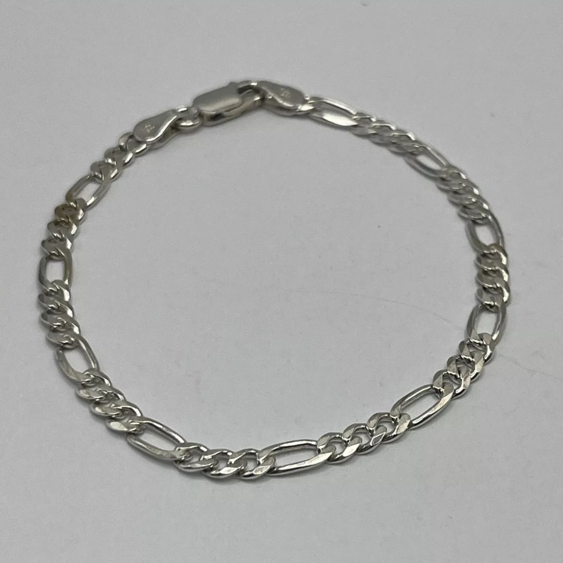 STERLING SILVER FIGARO BRACELET 7": STERLING SILVER FIGARO BRACELET 7" The product is a 7 inch Sterling Silver Figaro Bracelet made with 925 metal purity. This chain-style bracelet does not feature a main stone, making it a simple yet e