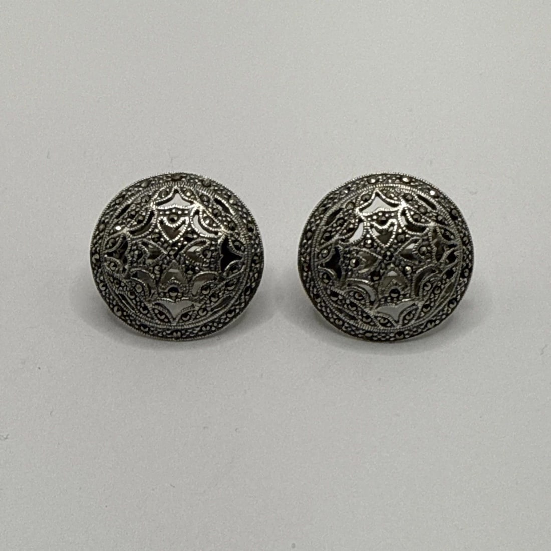 STERLING SILVER & MARCASITE ROUND EARRINGS: STERLING SILVER & MARCASITE ROUND EARRINGS Crafted with precision, these Sterling Silver & Marcasite Round Earrings exude a timeless elegance that complements any outfit. The stud design is classic, f