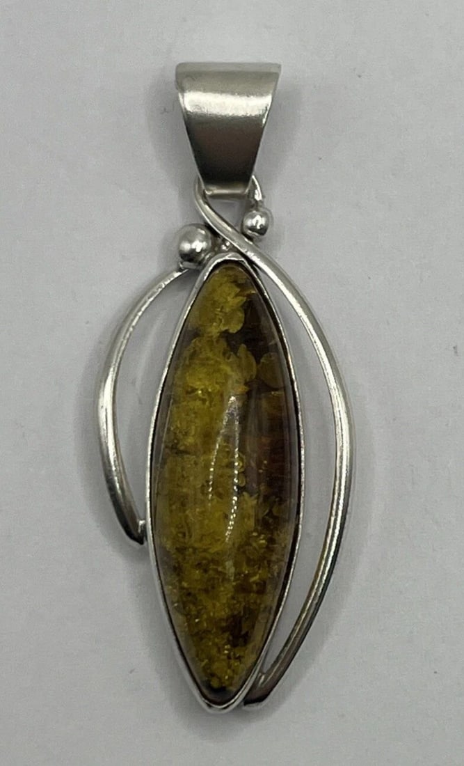 STERLING SILVER & AMBER PENDANT: STERLING SILVER & AMBER PENDANT This is a stylish pendant made of sterling silver with a beautiful amber stone as the main feature. The pendant has a brown color, adding a warm and earthy tone to the